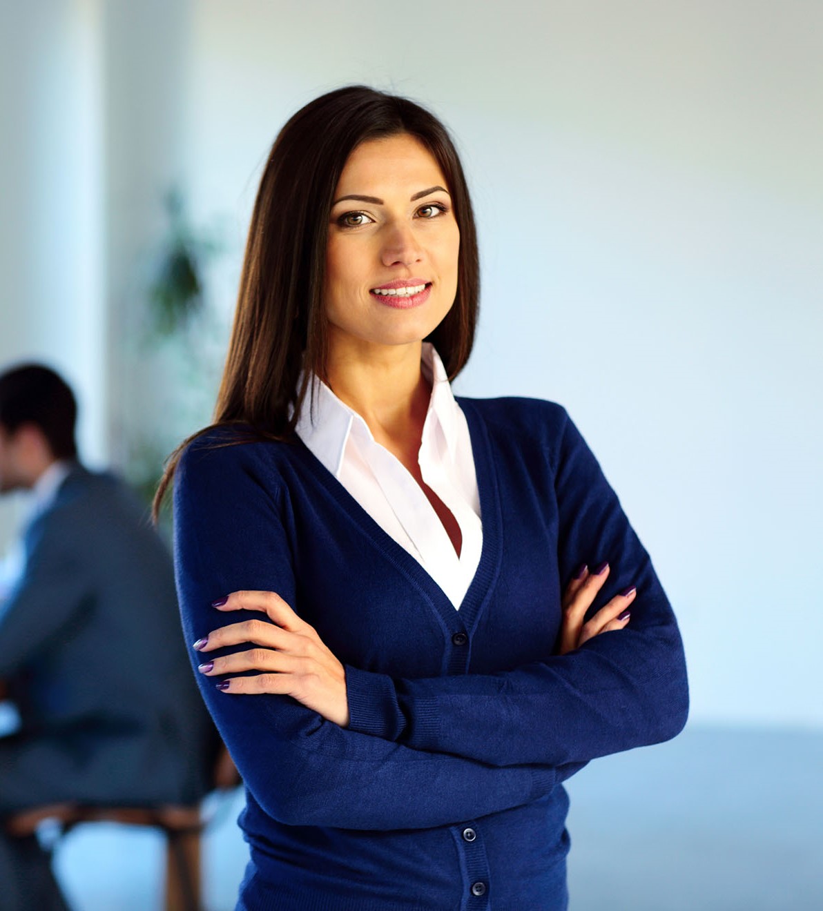 Smiling businesswoman standing with arms folded in front of colleagues Entrümpelung Münstertal (Schwarzwald)